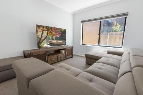 a living room with a couch and a flat screen tv at Lake Views Retreat in Paynesville