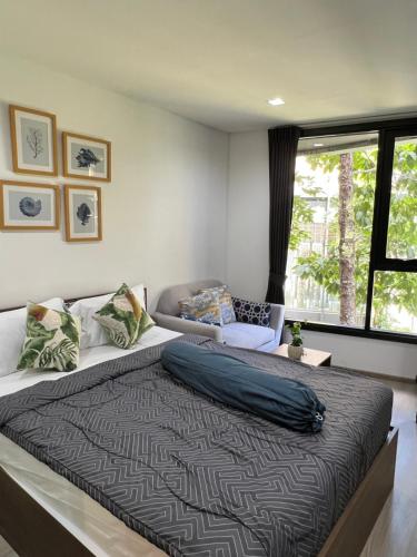 a bedroom with a large bed and a window at The Base Central Phuket-C4YW in Phuket