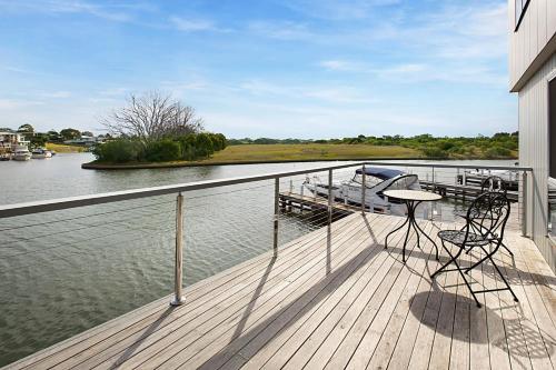a balcony with a table and chairs on the water at Pier 37 in Paynesville