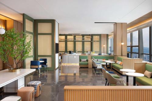a restaurant with tables and chairs and windows at Hilton Garden Inn Bazhong Bazhou in Bazhong