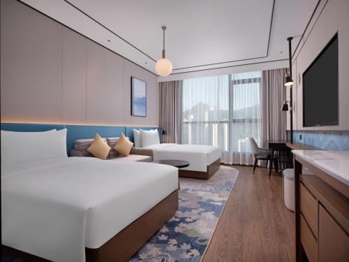 a hotel room with a bed and a couch at Hilton Garden Inn Bazhong Bazhou in Bazhong