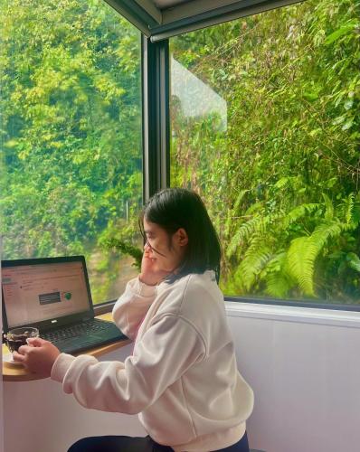 a woman sitting at a table with a laptop computer at Sapa Grand Blue Hotel in Sa Pa