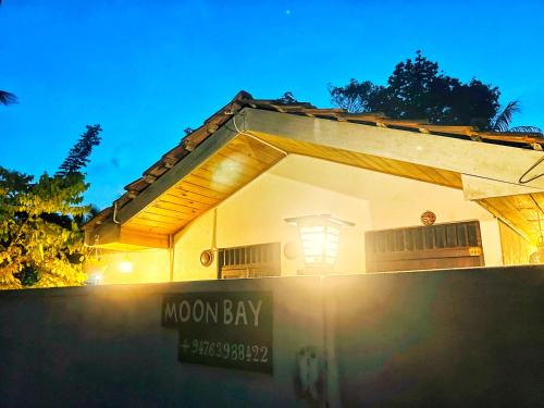 a house with a moon bay sign in front of it at Moon Bay in Mirissa
