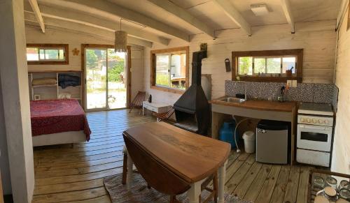 a room with a bedroom and a kitchen with a table at El Descanso in Neptunia