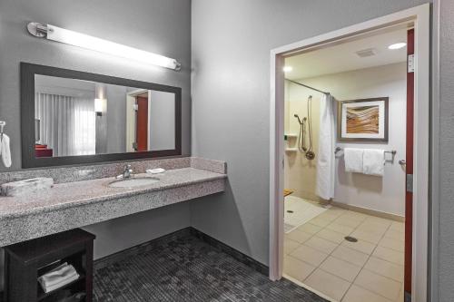 a bathroom with a sink and a mirror at Courtyard by Marriott Tulsa Woodland Hills in Tulsa