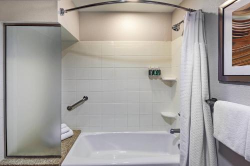 a bathroom with a tub and a shower curtain at Courtyard by Marriott Tulsa Woodland Hills in Tulsa
