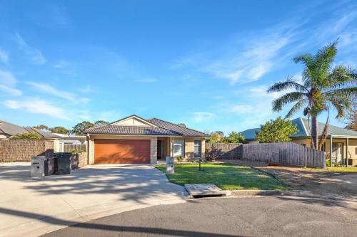 a house with a garage and a palm tree at Toonalook Retreat in Paynesville