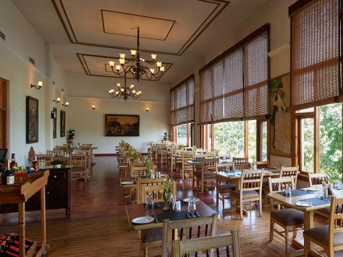 um restaurante com mesas e cadeiras e um lustre em Club Mahindra Mashobra em Mashobra
