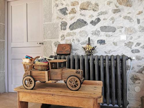 a wooden toy car sitting on a table next to a radiator at Escapade Romantique dans Ferme Restaurée avec Spa et Jardin à Yssingeaux - FR-1-582-500 in Yssingeaux