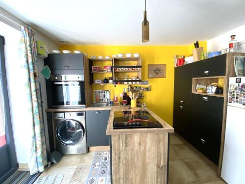 une cuisine avec un lave-linge et un lave-linge dans l'établissement Charmante maison rénovée au cœur de Groix - FR-1-813-12, à Groix