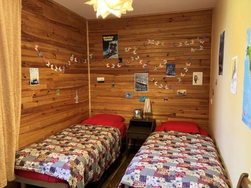 deux lits dans une chambre aux murs en bois dans l'établissement Charmante maison rénovée au cœur de Groix - FR-1-813-12, à Groix