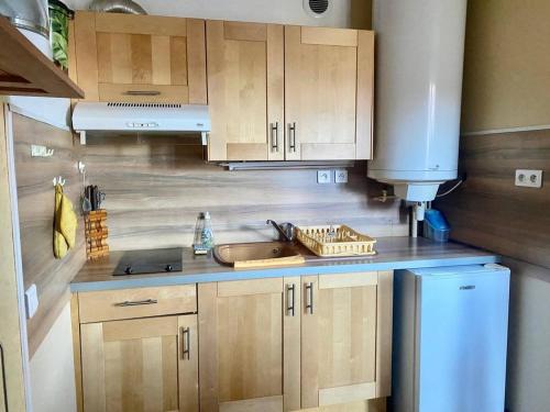 une cuisine avec des armoires en bois et un évier dans l'établissement Studio aux Thermes avec Parking et WIFI - FR-1-703-199, à Amélie-les-Bains-Palalda