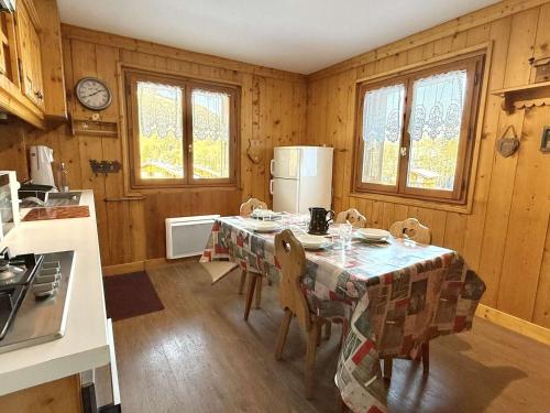 une cuisine avec une table avec des chaises et un réfrigérateur dans l'établissement Appartement 3 pièces à Praz-Sur-Arly - Près des pistes, parking, balcon - FR-1-603-113, à Praz-sur-Arly