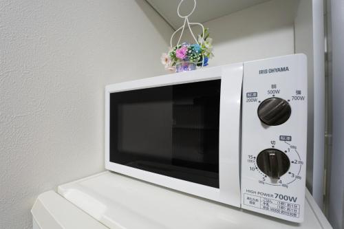 a white microwave oven sitting on top of a wall at Takasago Utopia Hotel in Tokyo
