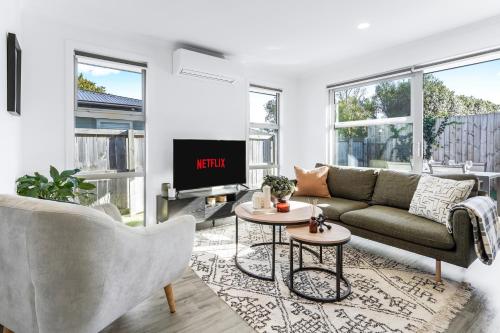 a living room with a couch and a tv at Stylish, Modern and Central in Hamilton