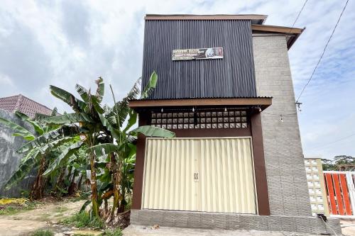 a building with a garage door and a sign on it at RedDoorz Syariah at Hostel Imah 3 Lampung in Kedaton
