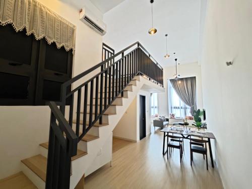 a staircase in a living room with a table and chairs at Sunway Grid by Antlerzone in Kangkar Pendas