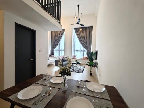 a dining room with a wooden table with flowers on it at Sunway Grid by Antlerzone in Kangkar Pendas