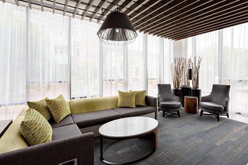 a living room with a couch and a table at Courtyard by Marriott Knoxville Downtown in Knoxville