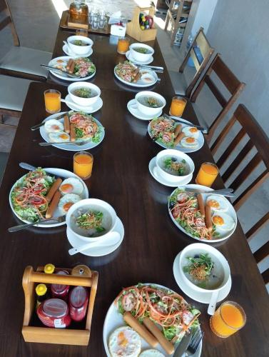 a long wooden table with plates of food on it at Doichang view-Sunset room in Ban Huai Khai