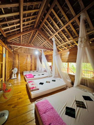 a room with four beds with mosquito nets at Nguyệt Nhi Homestay A Lưới in A Lưới (1)
