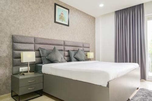 a bedroom with a large bed with white sheets at Housr Sector 28 Gurgaon Near IFFCO Chowk Metro Station in Gurgaon