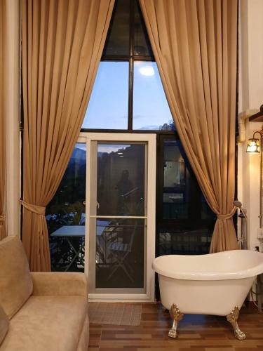 a bathroom with a tub in front of a large window at Blue Sky Monjam in Chiang Mai
