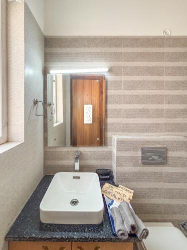 a bathroom with a white sink and a mirror at Housr Sector 28 Gurgaon Near IFFCO Chowk Metro Station in Gurgaon