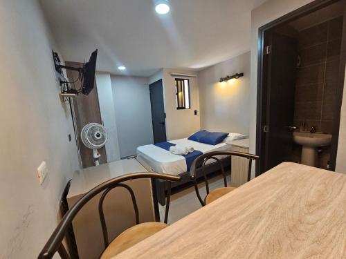 a room with two beds and a table and chairs at Andaliving Campo Valdés in Medellín