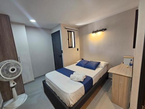 a small bedroom with a bed and a fan at Andaliving Campo Valdés in Medellín