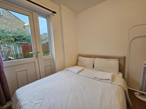 a small bedroom with a bed and a window at London E14 Rooms in London