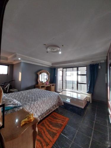 a bedroom with a bed and a large window at Mbele's home stay in Bloemfontein