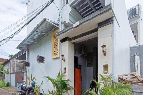 a white house with a red door at Widi Guest House near GWK Mitra RedDoorz in Jimbaran
