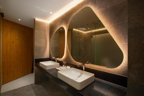 een badkamer met twee wastafels en een spiegel bij The Pino Khao Kho in Phetchabun