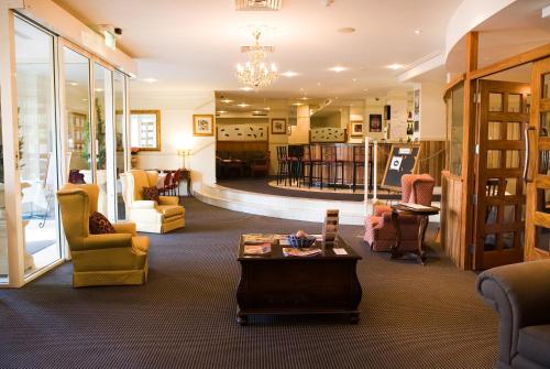 a lobby with chairs and a coffee table in a room at Redearth Boutique Hotel in Mount Isa