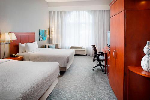 a hotel room with two beds and a television at Courtyard by Marriott San Antonio SeaWorld®/Westover Hills in San Antonio