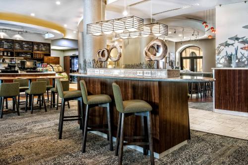 a lobby with a bar with stools in a restaurant at Courtyard by Marriott San Antonio SeaWorld®/Westover Hills in San Antonio