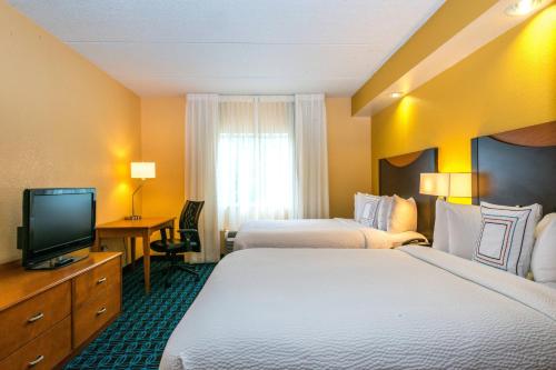 a hotel room with two beds and a television at Fairfield Inn & Suites by Marriott Nashville at Opryland in Nashville