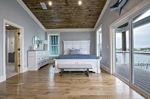 a bedroom with a white bed and a large window at Cowboy at Sunset Key in Pensacola