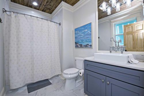 a bathroom with a sink and a toilet and a shower at Cowboy at Sunset Key in Pensacola