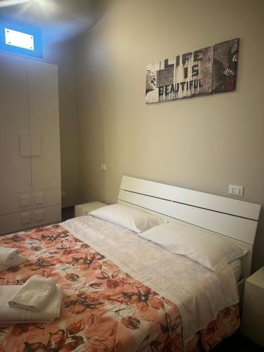 a bedroom with a large bed with a poster on the wall at B&B Scilla Town in Scilla