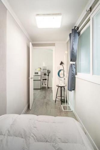 a white bedroom with a bed and a desk at Comfy & Cozy in Seoul