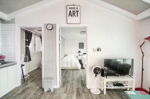 a white living room with a bed and a tv at Comfy & Cozy in Seoul