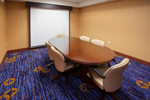 a conference room with a table and chairs and a screen at Courtyard Louisville Northeast in Louisville