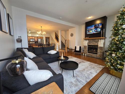a living room with a couch and a christmas tree at Mountain Escape for Ski and Golf Enthusiasts in Kimberley