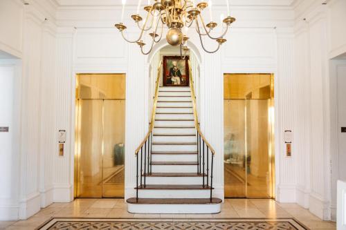a staircase in a building with a chandelier at The Lafayette New Orleans by Kasa Living in New Orleans