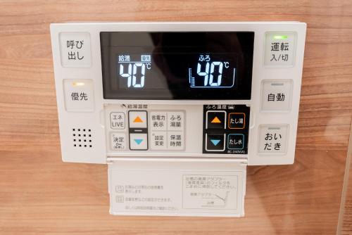 an electronic machine with a remote control on a table at 新筑Jr山手線鶯谷徒步3分直达上野 秋叶原 新宿 涩谷 池袋 原宿 银座 成田机场独栋四层110平别墅 in Tokyo
