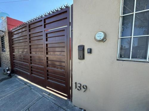 eine hölzerne Garagentür mit einer Uhr an der Seite eines Hauses in der Unterkunft Casa en Pesquería NL, cerca del Aeropuerto de Monterrey in Villa Juárez