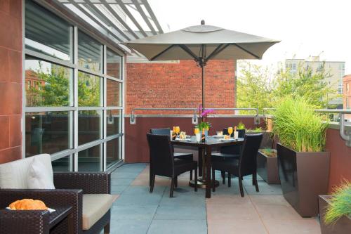 a patio with a table and chairs and an umbrella at Courtyard by Marriott Seattle Everett Downtown in Everett
