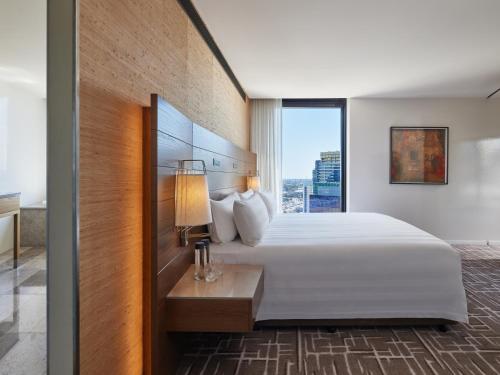a hotel room with a large bed and a window at Pan Pacific Melbourne in Melbourne
